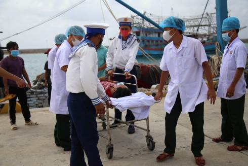 Cán bộ, chiến sĩ đảo Trường Sa đưa ngư dân Nguyễn Đức An vào đảo chữa trị.