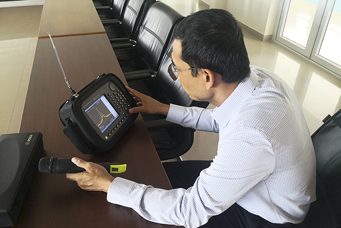 Cán bộ Trung tâm Tần số vô tuyến điện khu vực VII kiểm tra thông số kỹ thuật  của thiết bị âm thanh không dây ở một đơn vị tổ chức sự kiện.