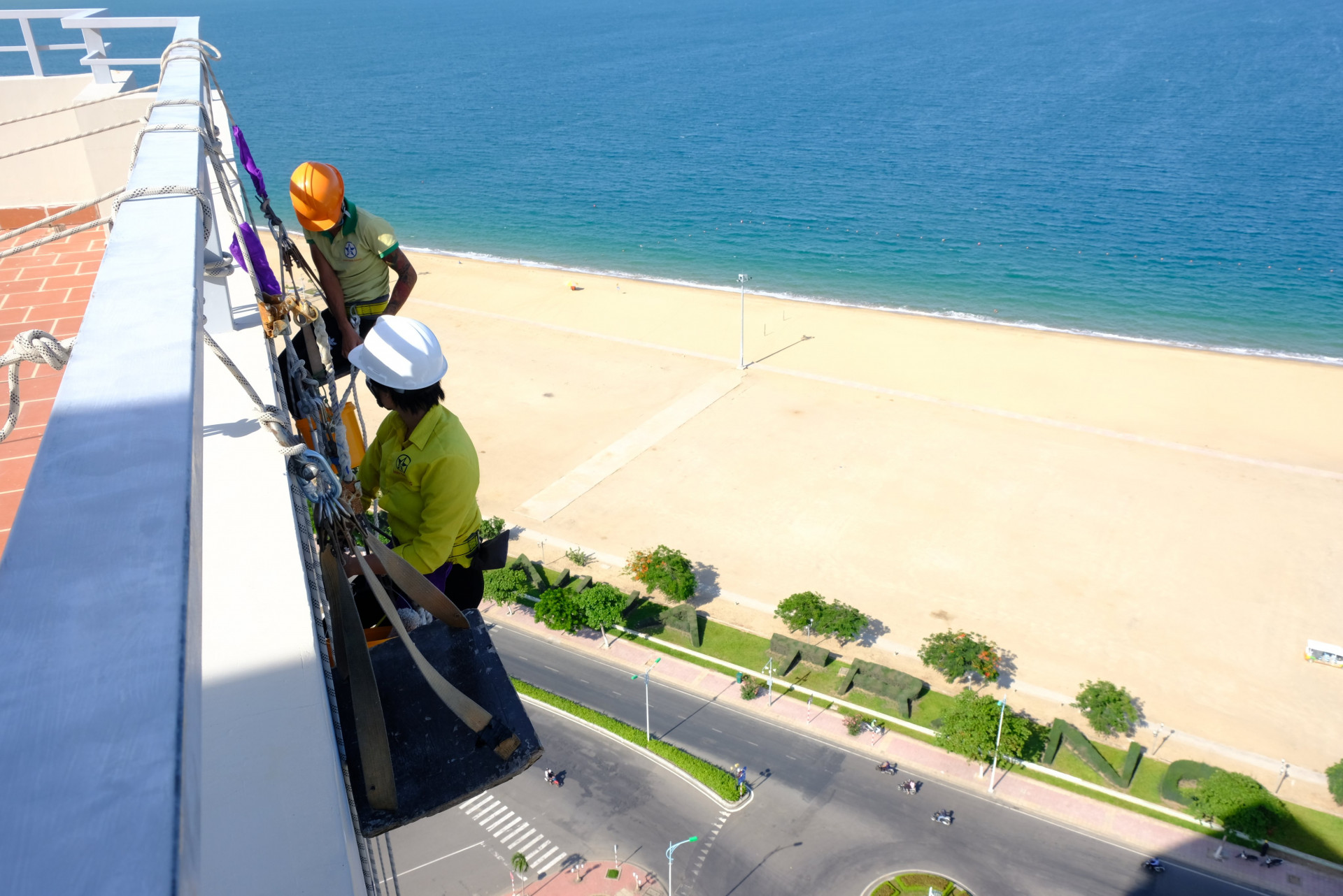 Trên công trường, chị Quyên hóa “người nhện” đu dây, lau kính - Ảnh: V.HIẾN