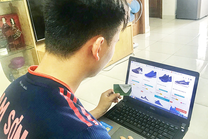 Một bạn trẻ ở Nha Trang đang chọn mua giày qua mạng.