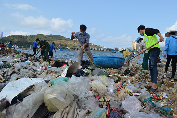 Lãnh đạo xã Phước Đồng tham gia dọn rác cùng người dân.