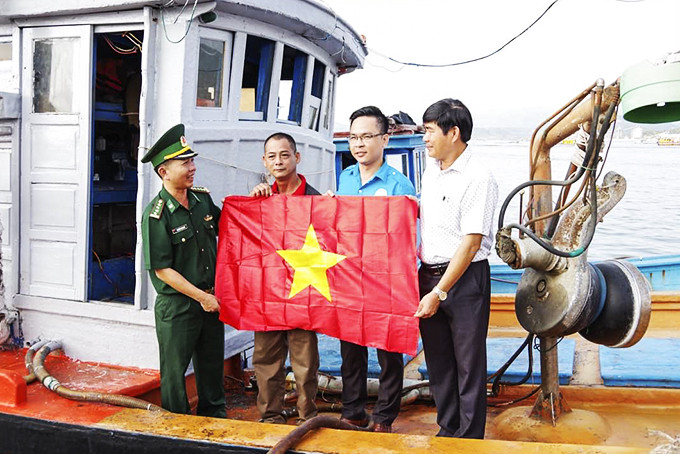 Bộ đội Biên phòng tỉnh phối hợp với các đơn vị trao tặng cờ Tổ quốc  cho ngư dân TP. Cam Ranh.