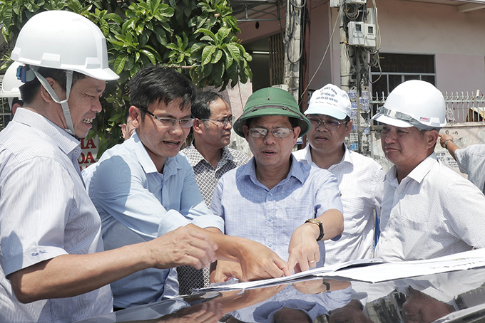 Ông Nguyễn Tấn Tuân (giữa) trao đổi tiến độ các dự án với các sở, ngành.