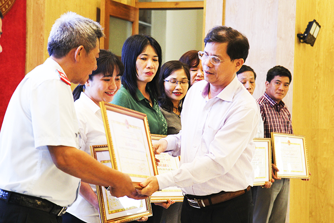 Ông Nguyễn Tấn Tuân trao bằng khen của UBND tỉnh cho các tập thể.