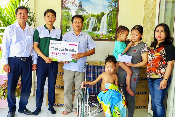 Đại diện Báo Khánh Hòa và Vietcombank Nha Trang  trao tiền ủng hộ cho gia đình 2 cháu Vinh - Tuấn.