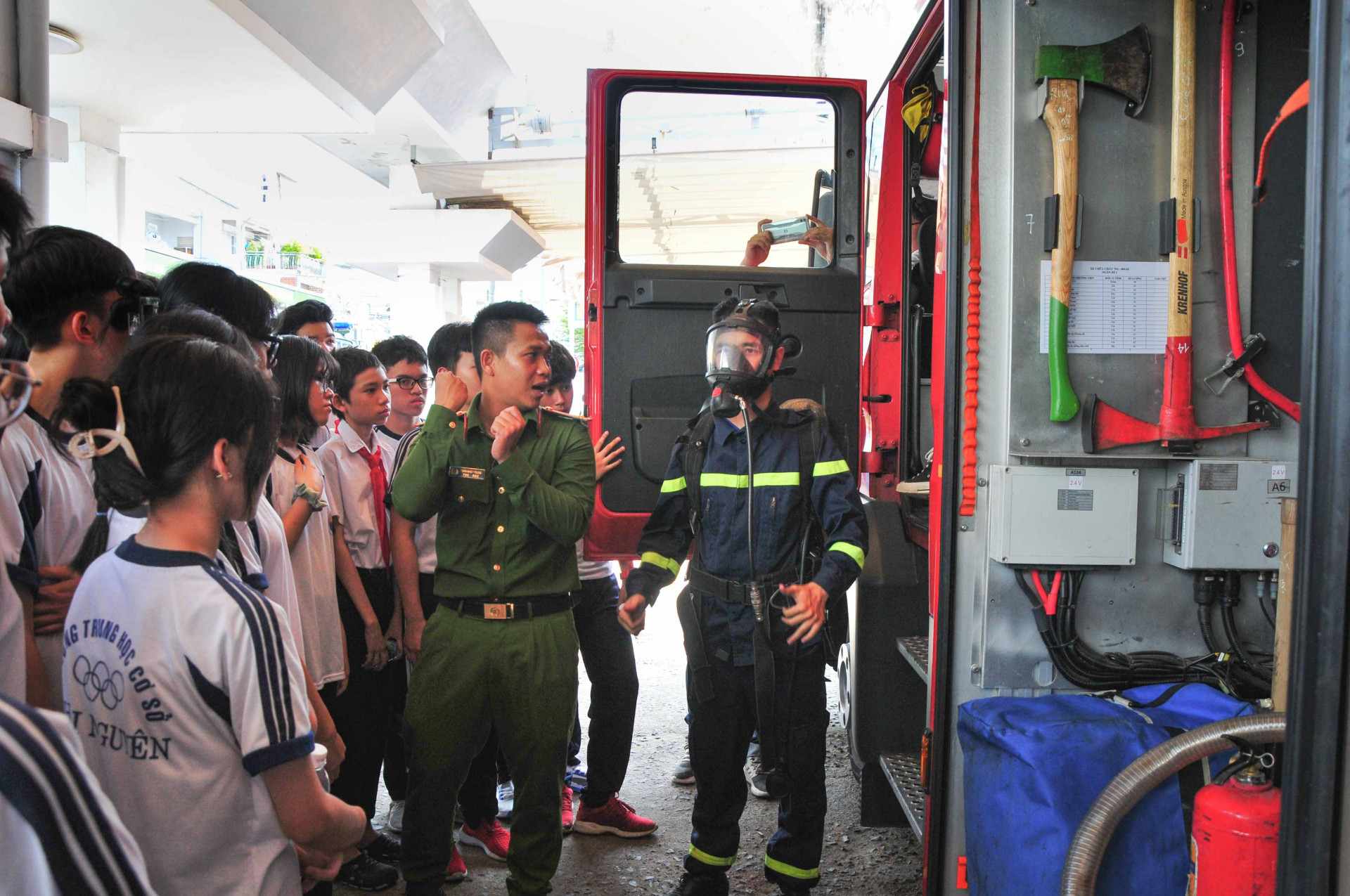 Các học sinh tìm hiểu về trang thiết bị PCCC và cứu nạn cứu hộ trên xe cứu hoả