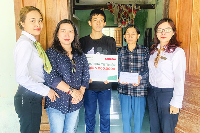 Đại diện Báo Khánh Hòa và Vietcombank Nha Trang trao tiền ủng hộ cho cháu Nguyễn Lê Thiên.