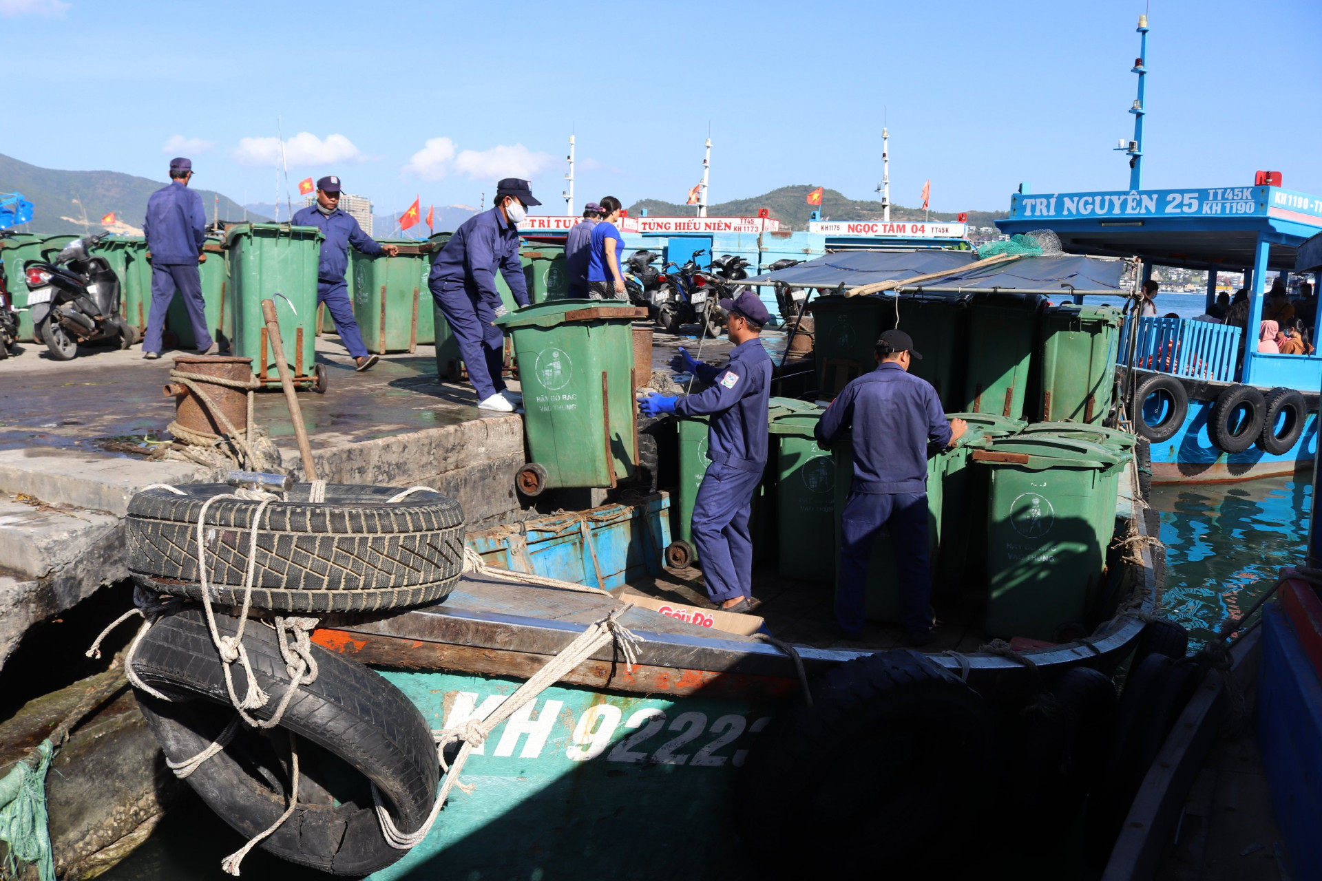 Công nhân vận chuyển thùng rác từ đảo Trí Nguyên lên thuyền.