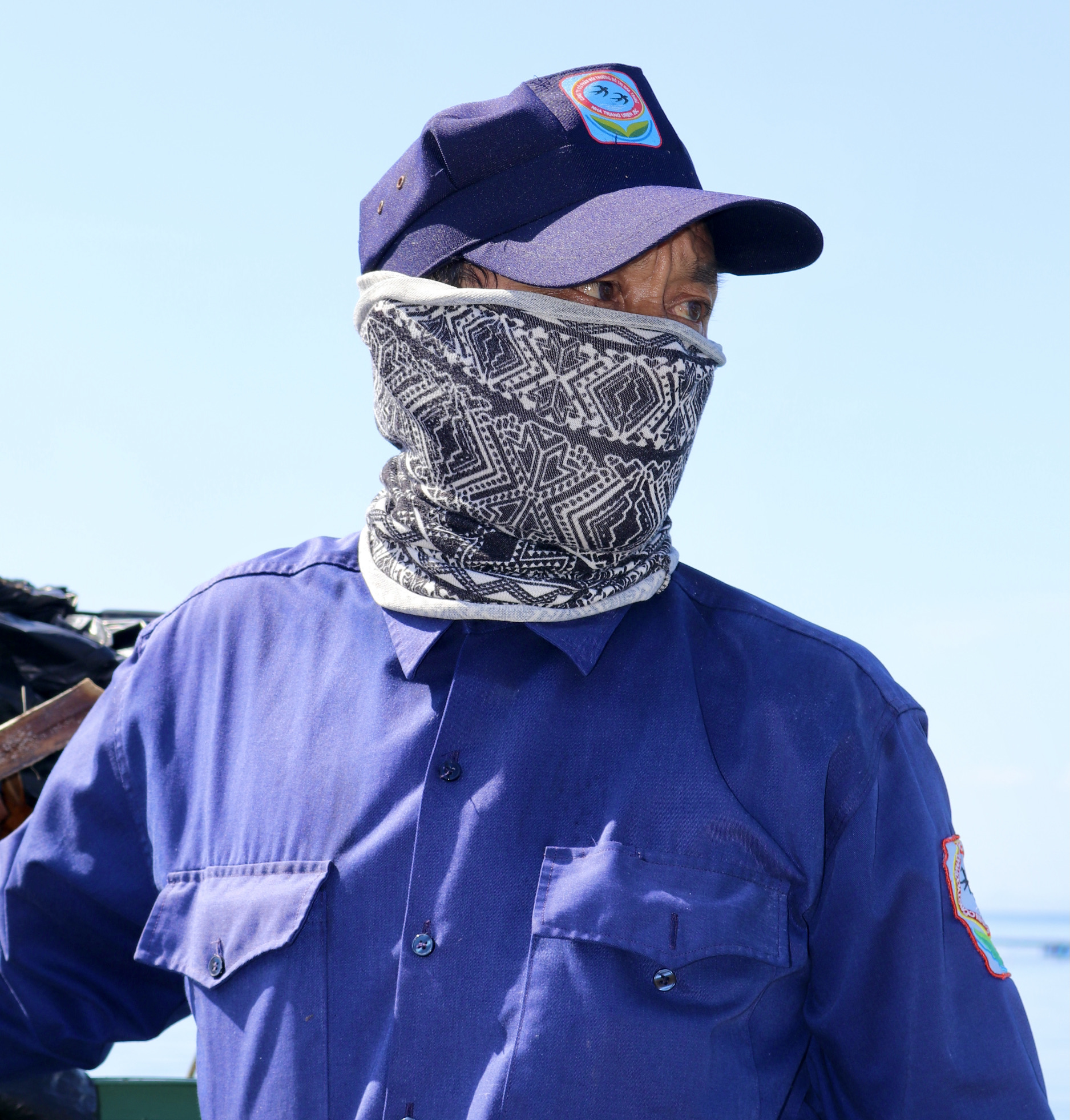 Ông Nguyễn Khắc Tân (57 tuổi, một công nhân) bịt kín mặt khi thu gom rác trên biển.
