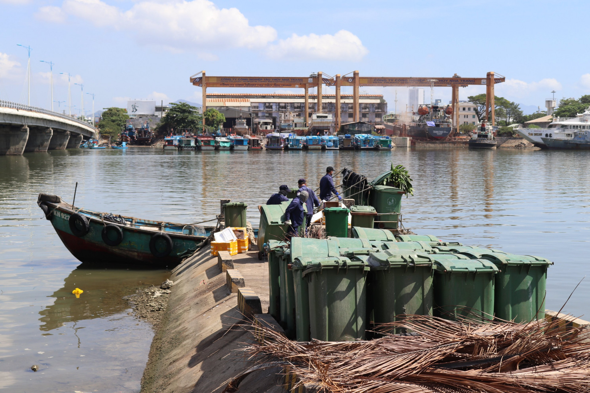 Vận chuyển các thùng rác từ thuyền lên đất liền ở chân cầu Bình Tân.