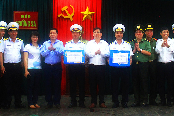 Đồng chí Nguyễn Tấn Tuân và đồng chí Hà Quốc Trị cùng đoàn công tác  trao quà cho quân và dân thị trấn Trường Sa. 