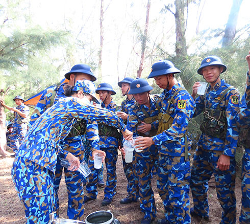 Các hội viên phụ nữ mang nước ra thao trường cho các chiến sĩ