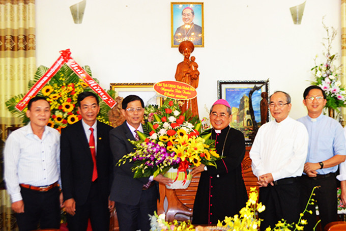 Ông Nguyễn Tấn Tuân tặng hoa chúc mừng Đức Giám mục Giuse Võ Đức Minh.