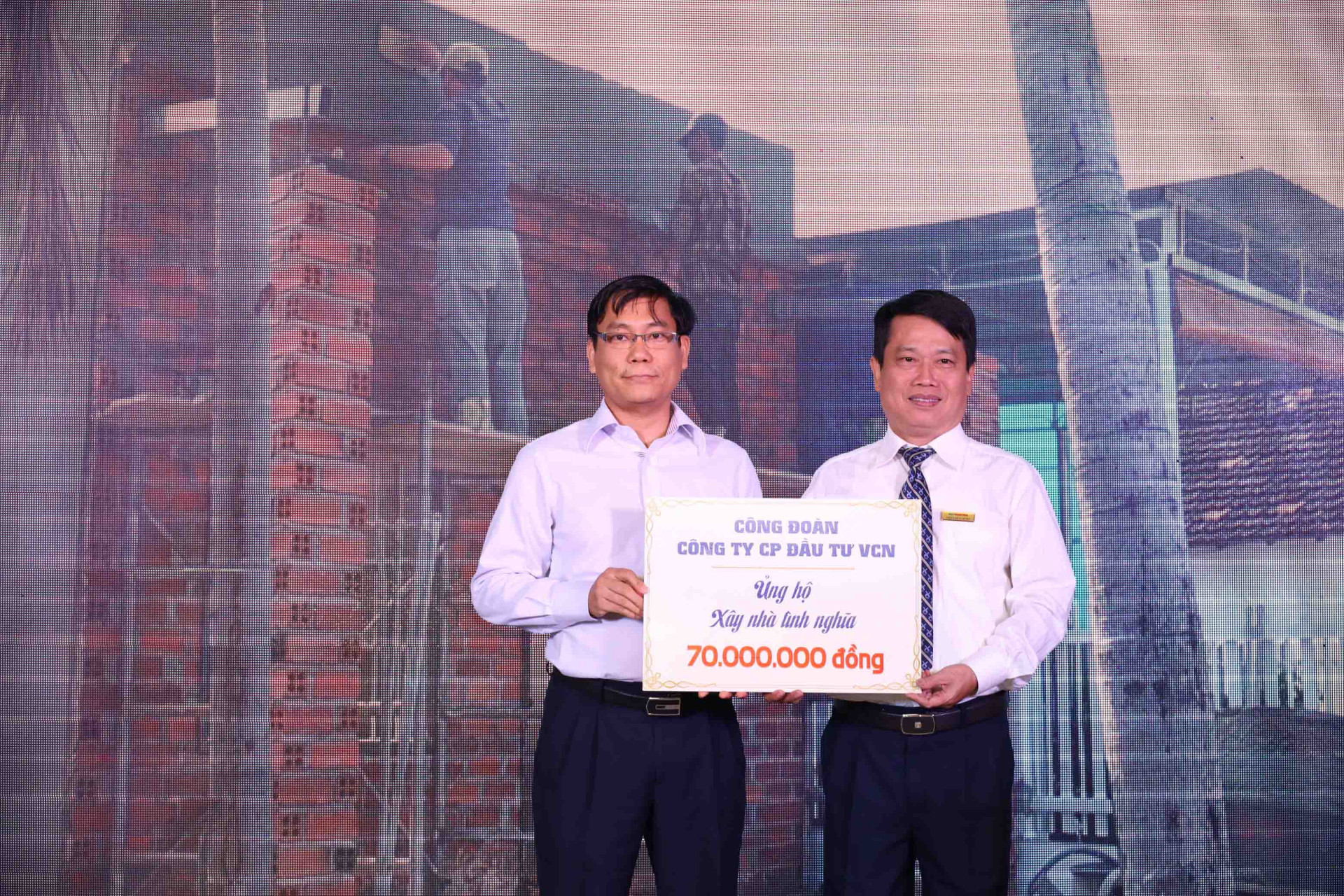 Đại diện Công ty Cổ phần đầu tư VCN trao bảng tượng trưng kinh phí ủng hộ xây nhà cho người dân xã Suối Cát. 