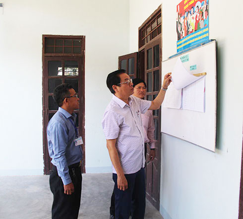 Ông Trần Mạnh Dũng kiểm tra việc niêm yết danh sách cử tri tại xã Cam Hiệp Nam.