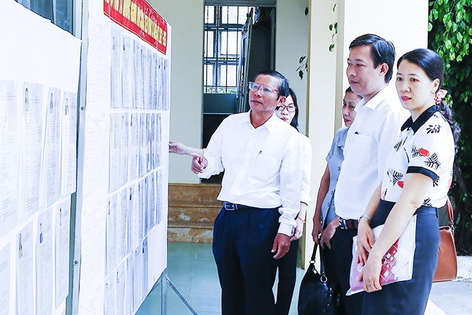 Đoàn kiểm tra  việc niêm yết danh sách  người ứng cử tại UBND xã Ninh Bình.