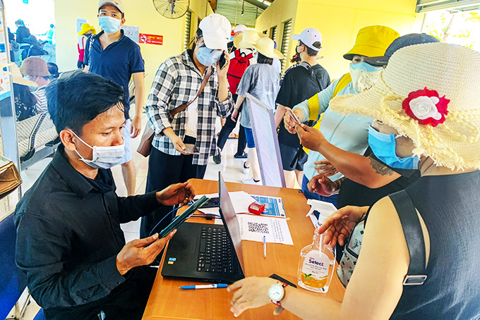 Nhân viên Bến tàu Du lịch Nha Trang hướng dẫn khách khai báo y tế trước khi đi tham quan tour biển, đảo.