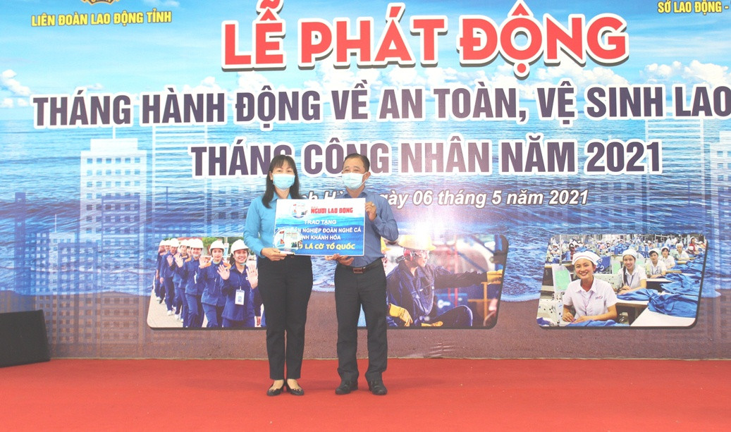 Đại diện Liên đoàn Lao động tỉnh Khánh Hòa tiếp nhận cờ tổ quốc do Báo Người Lao Động trao cho ngư dân các nghiệp đoàn nghề cá.