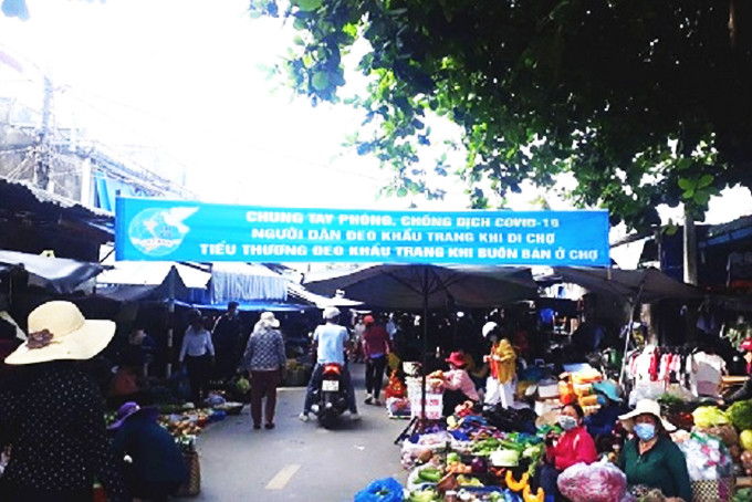 Hội Phụ nữ thị trấn Cam Đức treo băng rôn tuyên truyền tại chợ Cam Đức.