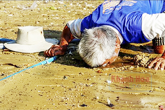 Một người Đàng Hạ cào lớp cát mỏng để uống nước ngọt.