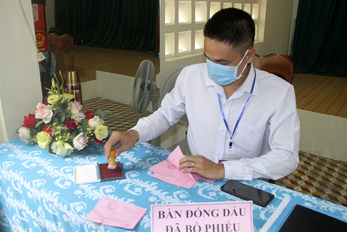 Thành viên tổ bầu cử khu vực số 4 phường Tân Lập, Tp. Nha Trang đóng dấu hoàn thành bầu cử vào thẻ cử tri