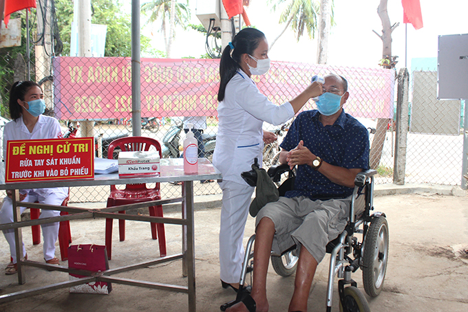 Tuy bị khuyết tật chân, nhưng ông Phan Thanh Tâm cử tri thị trấn Vạn Giã vẫn tự đi xe lăn đến điểm bỏ phiếu.