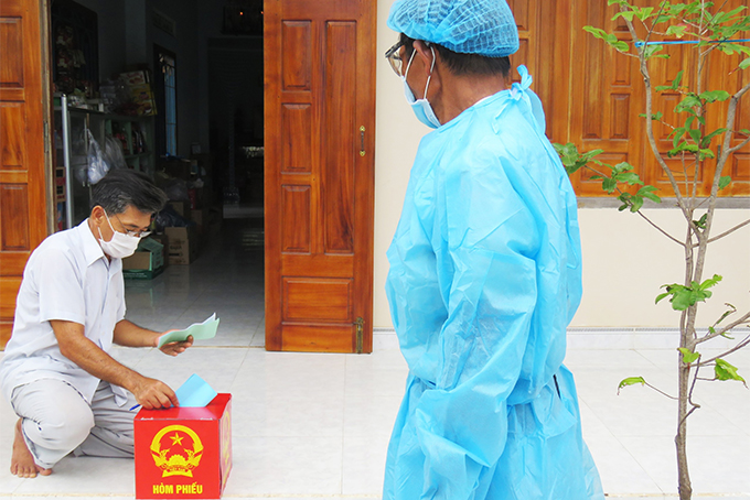 Cử tri cách ly vì Covid-19 thực hiện bỏ phiếu tại nhà, ảnh chụp tại xã Xuân Sơn, Vạn Ninh.