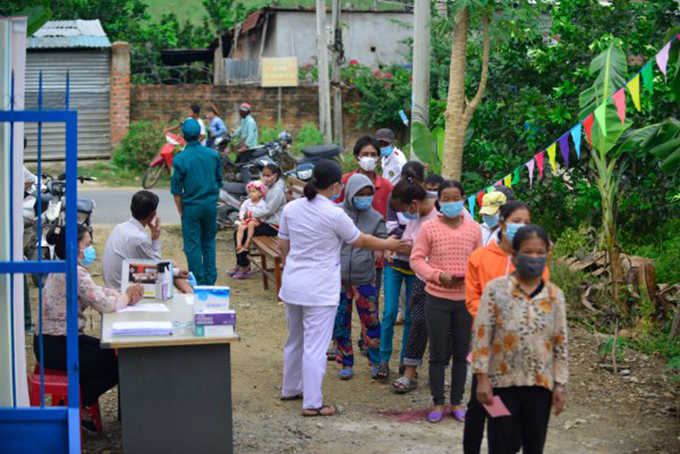 Nhân viên y tế tại khu vực bỏ phiếu số 3 (xã Khánh Nam, huyện Khánh Vĩnh) nhắc nhở cử tri giữ giãn cách để phòng chống dịch Covid-19. Ảnh: NHỤT HỒNG.