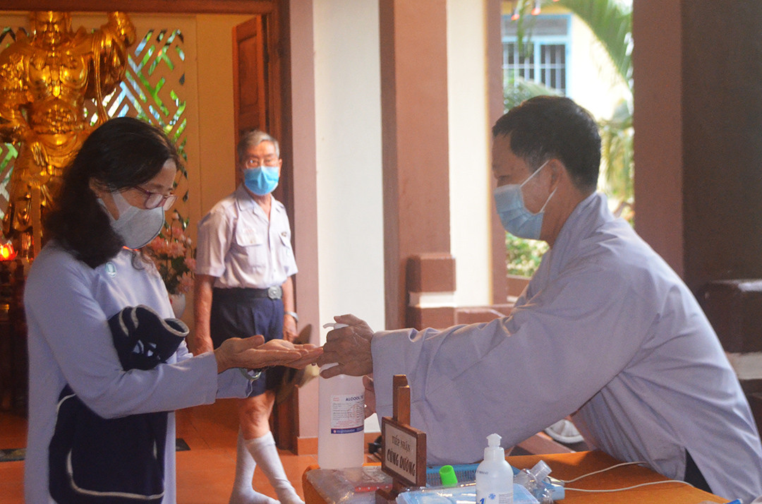 Attendees washing hands with sanitizer and wearing masks 