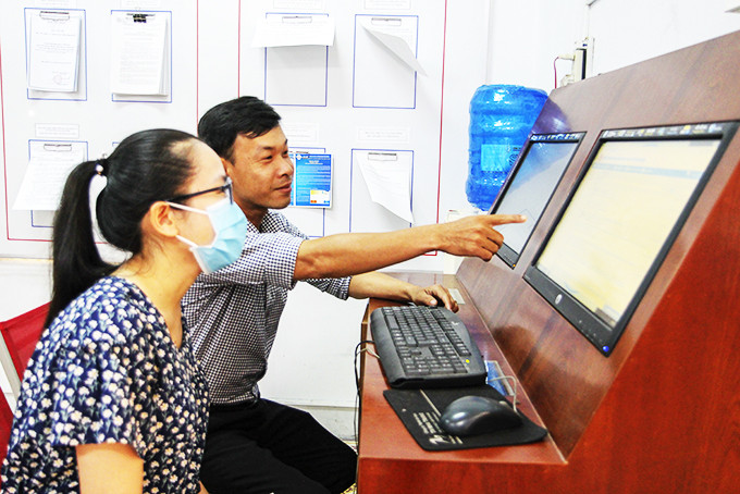 Công chức bộ phận một cửa Sở Văn hóa và Thể thao hướng dẫn người dân nộp hồ sơ trực tuyến.