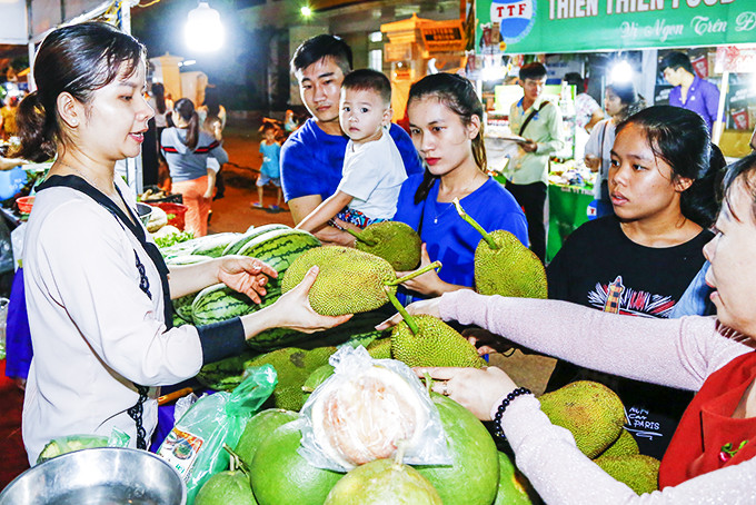 Người dân và du khách tham quan, mua sắm vào ban đêm tại Phiên chợ Nông sản Khánh Hòa 2019.