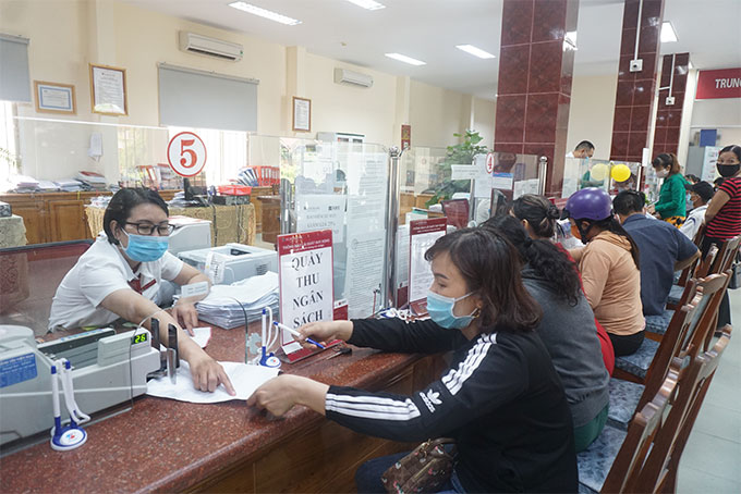 Giao dịch viên Agribank Chi nhánh huyện Diên Khánh hướng dẫn khách hàng hoàn thiện chứng từ nộp ngân sách nhà nước tại ngân hàng.