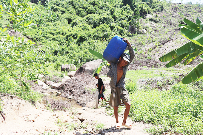 Người dân xã Khánh Trung (huyện Khánh Vĩnh) lấy nước nguồn  ở núi Hòn Mưa về sử dụng.
