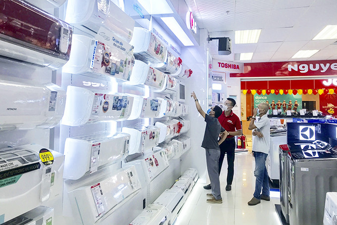 Người dân tìm hiểu máy điều hòa tại Trung tâm mua sắm Nguyễn Kim. 