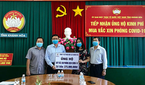 Đại diện Công ty Cổ phần Điện lực Khánh Hoà (thứ 2 từ trái qua) trao tượng trưng tiền hỗ trợ mua vắc xin