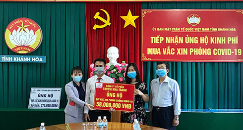 Đại diện Công ty cổ phần Toyota Nha Trang (thứ 2 từ trái qua) trao tượng trưng kinh phí hỗ trợ mua vắc xin