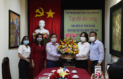 Ông Hà Quốc Trị (thứ 3 từ trái qua) tặng hoa chúc mừng tập thể Tạp chí Nha Trang. 