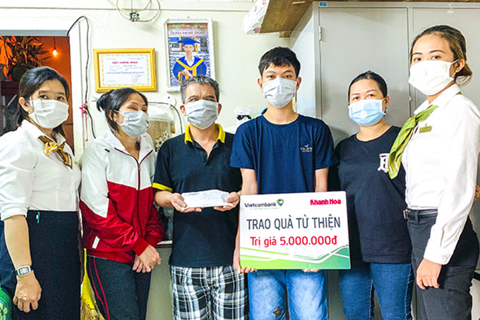 Đại diện Báo Khánh Hòa và Vietcombank Nha Trang  trao tiền ủng hộ cho gia đình anh Ngô Ngọc Tèo.