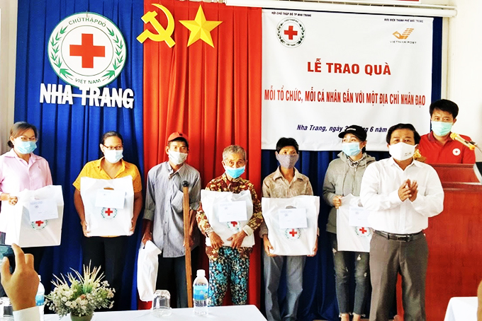 Đại diện Hội Chữ thập đỏ TP. Nha Trang trao quà cho các gia đình.