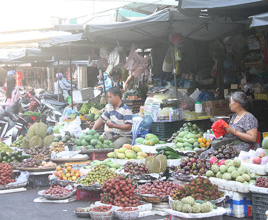 Rất nhiều người bán trái cây ở khu vực chợ Xóm Mới không đeo khẩu trang trong quá trình bán hàng.