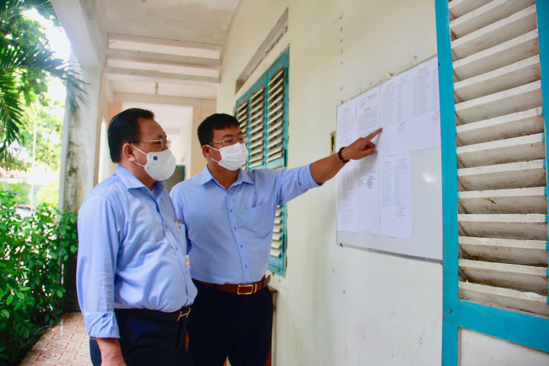 Ông Lê Hữu Hoàng kiểm tra quy định thi được dán trước phòng thi tại điểm thi trường THPT Lạc Long Quân, huyện Khánh Vĩnh.