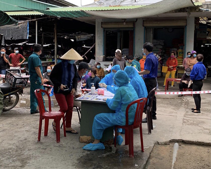 Lực lượng chức năng lấy mẫu xét nghiệm cho các tiểu thương ở chợ Cam Lộc vào ngày 6-7