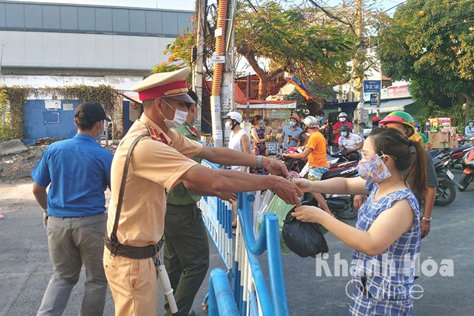 Lực lượng cảnh sát giao thông giúp dân đưa lương thực, thực phẩm cho người dân bên trong khu vực phong tỏa Hòn Rớ, Nha Trang.