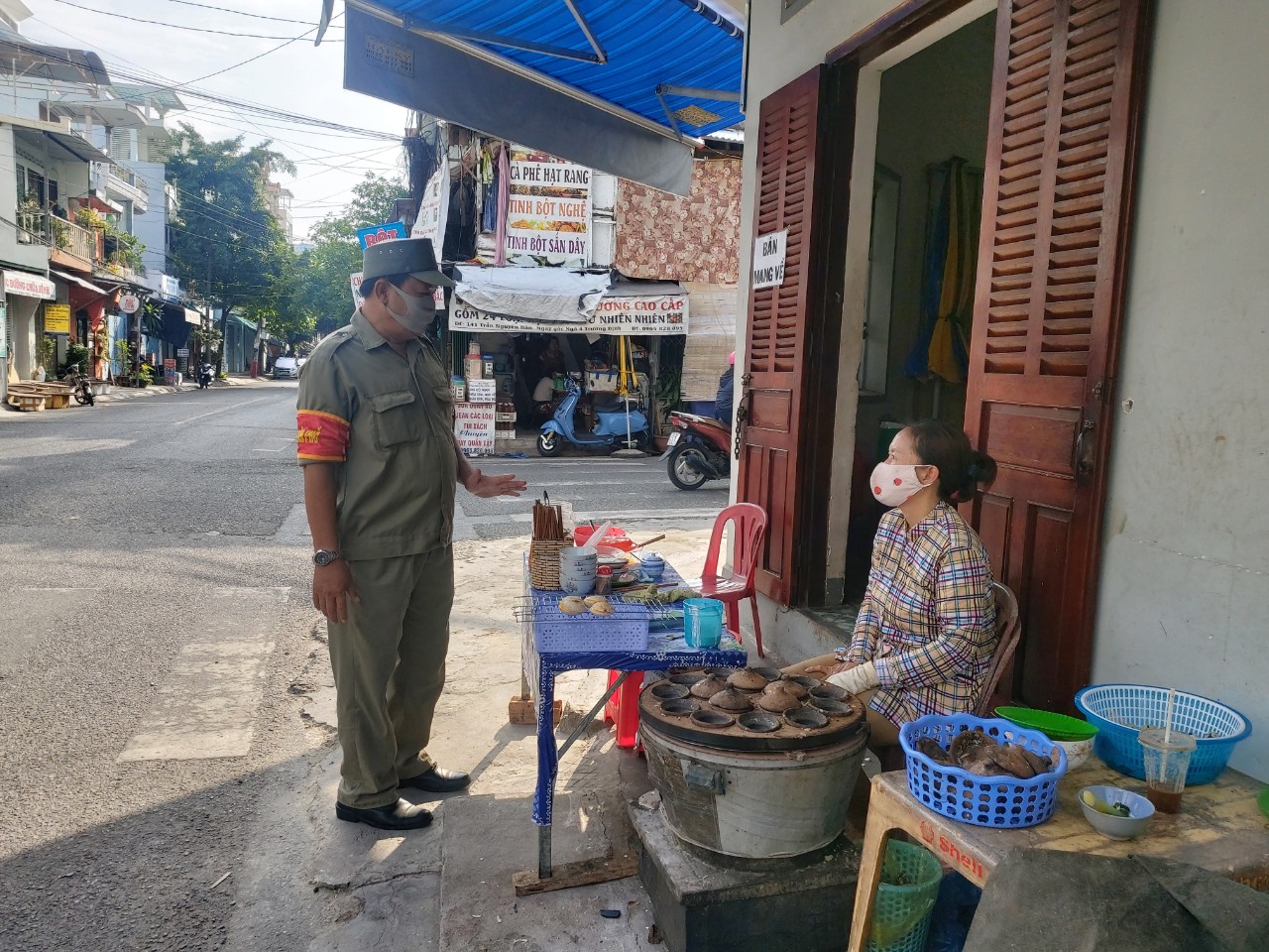 A functional staff member warning a food vendor about social distancing regulations