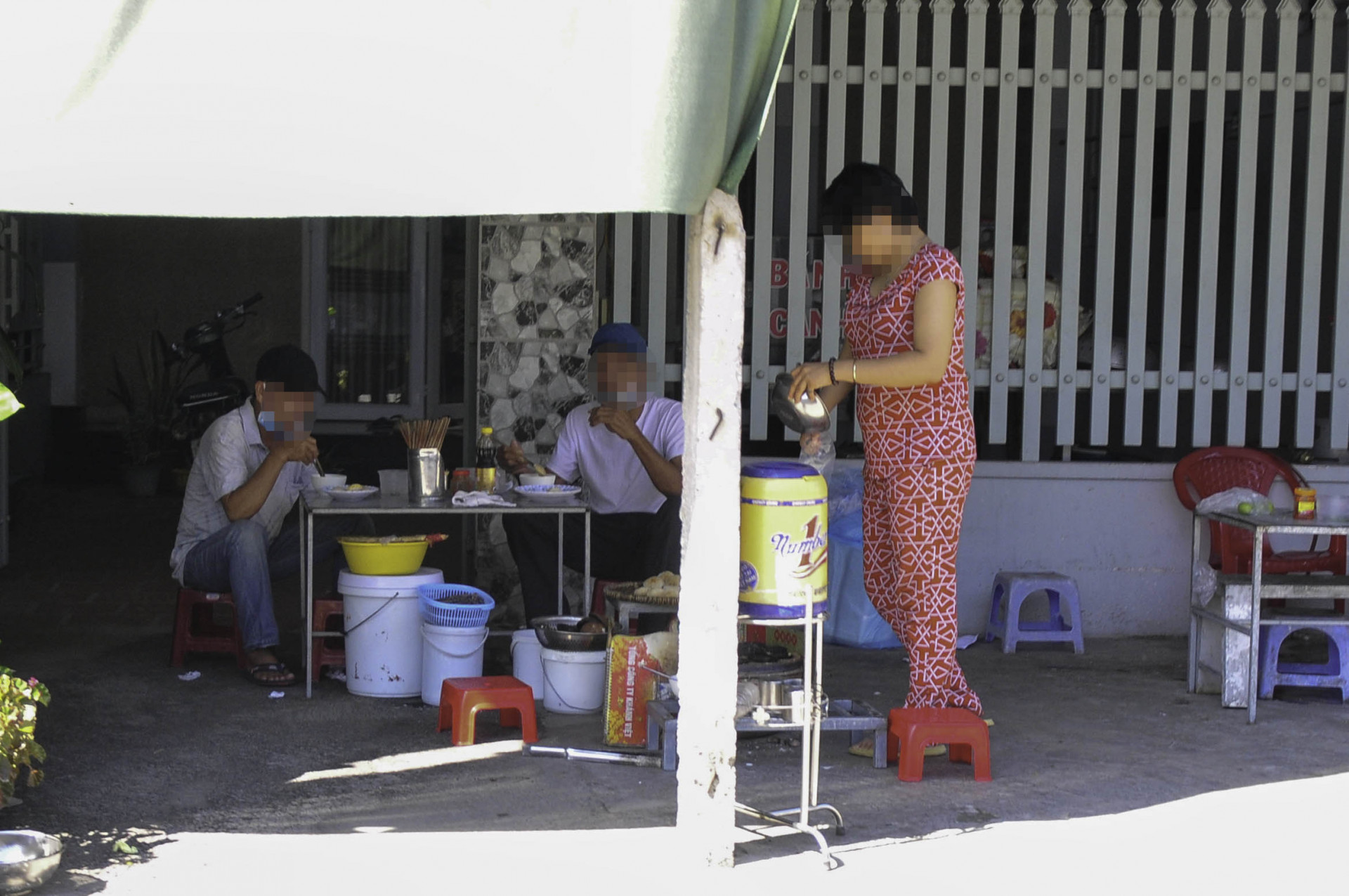 Một quán ăn vỉa hè trên đường Lương Định Của (đoạn qua xã Vĩnh Ngọc) vẫn mở bán, khách đến ăn tại chỗ 