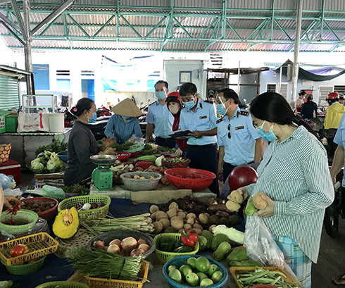 Lực lượng quản lý thị trường nắm tình hình giá rau tại chợ Phương Sơn