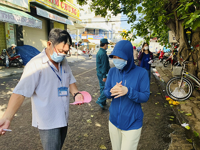  Nhân viên BQL chợ Xóm Mới đang kiểm tra phiếu vào chợ của chị Nguyễn Phạm Hồng Như, sống ở chung cư HUD, phường Phước Long, TP. Nha Trang