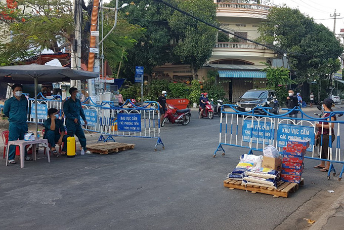 Người dân khu phong tỏa ở Hòn Rớ (xã Phước Đồng) nhận lương thực, thực phẩm từ bên ngoài. Ảnh: VĂN KỲ