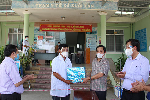 Ông Hà Quốc Trị trao quà hỗ trợ của Thường trực Tỉnh ủy cho Trung tâm điều hành công tác phòng chống dịch cánh Bắc huyện Cam lâm (đóng tại Trạm Y tế xã Suối Tân)
