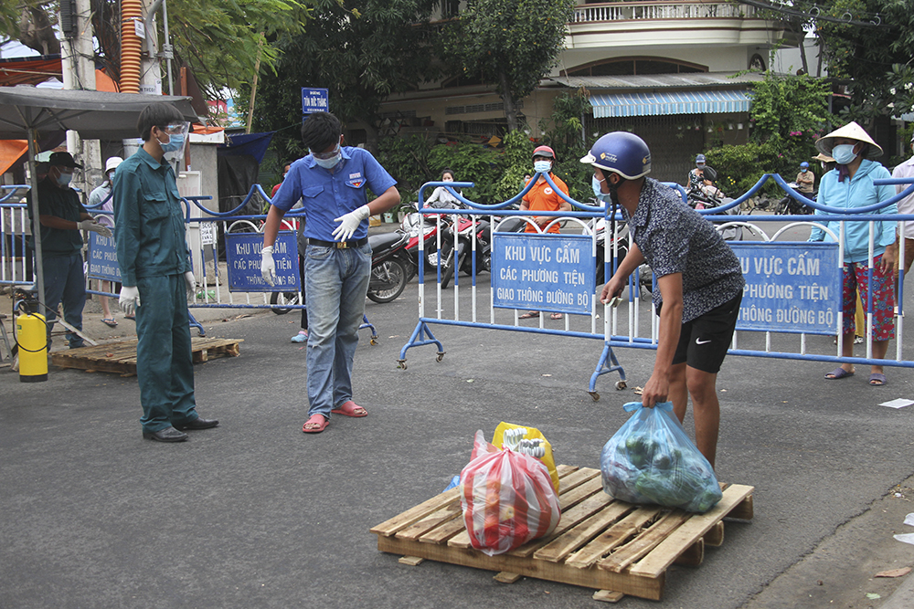 Tiếp tế thực phẩm cho người dân trong khu vực bị phong tỏa tạm thời ở khu Hòn Rớ, xã Phước Đồng